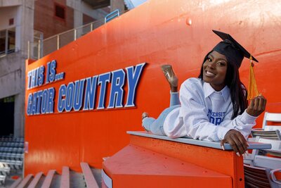 uf graduation pictures girl posing in front of gator country sign