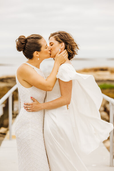 two brides kiss with CA mountains in distance
