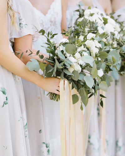 Close-up photo of bouquets with white flowers and greenery