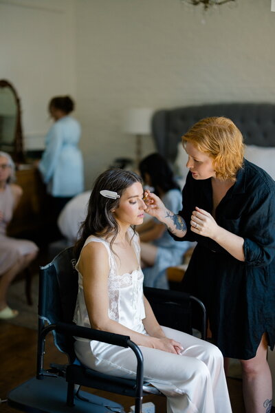 Audra applying natural makeup on bride before wedding