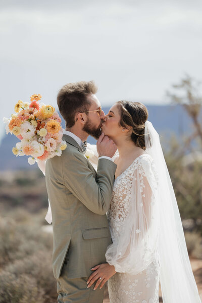 bride and groom hugging  with bridal bouquet over groom's shoulder