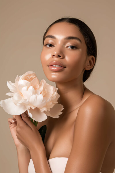 Woman smiling softly with flowers, symbolizing steady progress and real support from Desert Bloom Health and Wellness