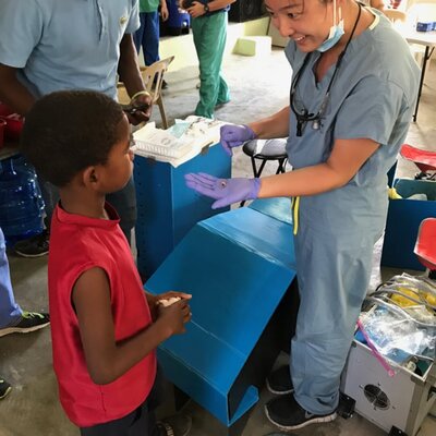 doctor medical student showing tooth to little boy