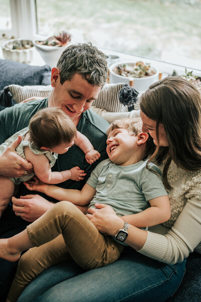 three kids laughing on blanket