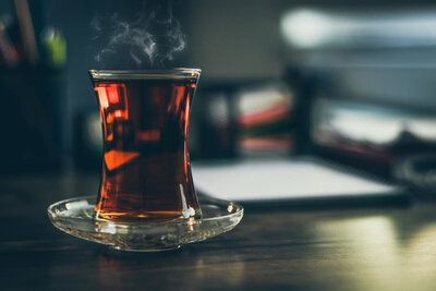 Steaming cup of tea in a clear glass mug.