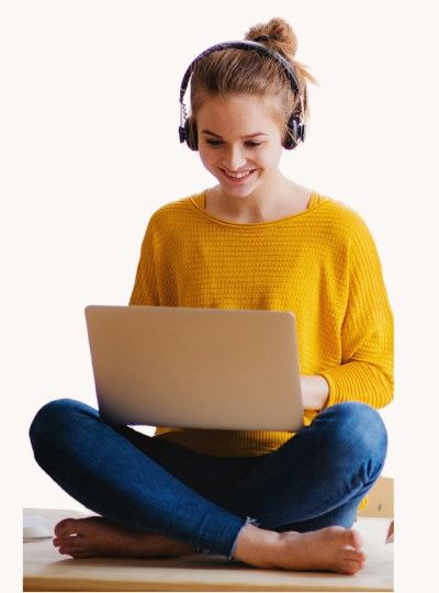A lady in a yellow jumper using a laptop with her headphones on