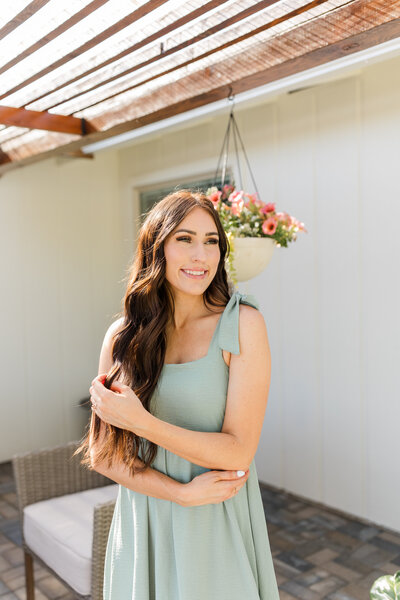 Kali, a wedding and senior photographer in Lewiston, Idaho, smiling in a sunlit outdoor setting.