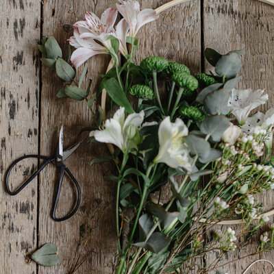 Individual flowers laying on a surface next to floral shears