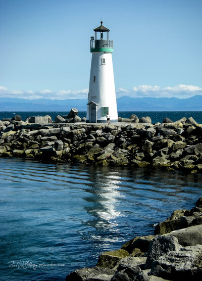 Santa Cruz Harbor’s Walton Lighthouse and its reflection on a clear afternoon in Santa Cruz, CA.