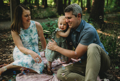 Newborn photoshoot with dad hugging young child.