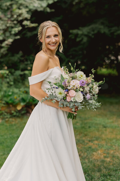 Bride posing with bouquet in garden