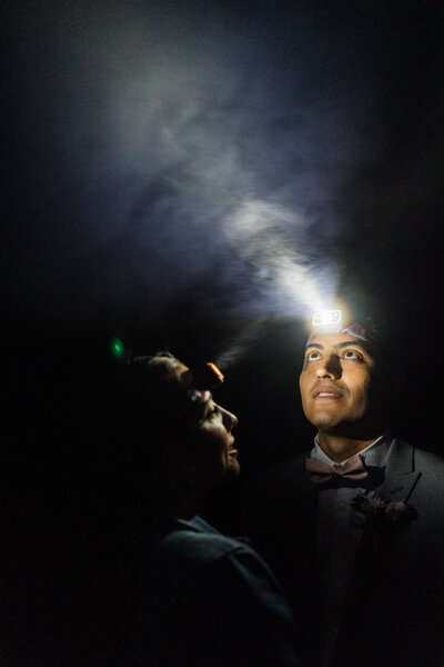 elopement couple staring into headlamps surrounded by fog at Mt Rainier