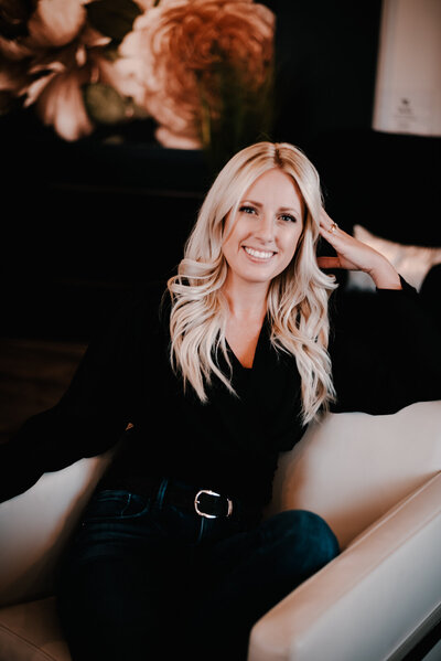 Clean professional headshot of Ally Saunders sitting in a chair, ideal for business websites and branding