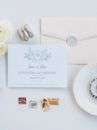 A wedding magazine surrounded by a Canon camera, red and pink cloth, flowers, leaves and a wedding ring