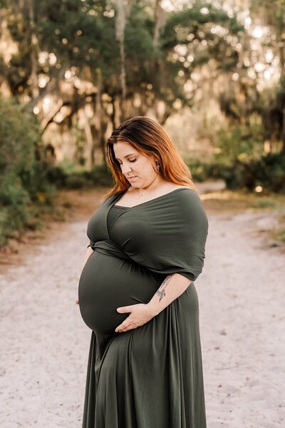 Pregnant woman in green dress by Orlando maternity photographer Haleigh Nicole