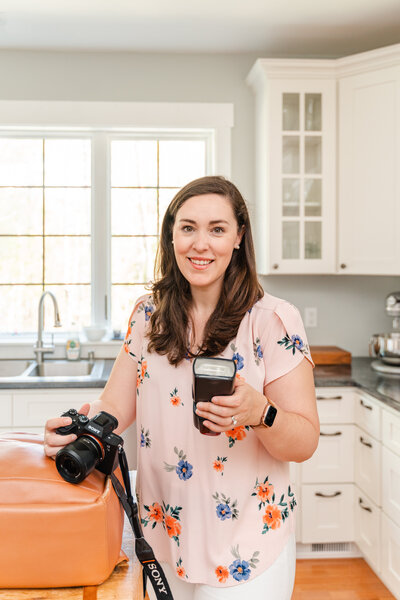 Photography educator Kelley Hoagland holds flash in kitchen