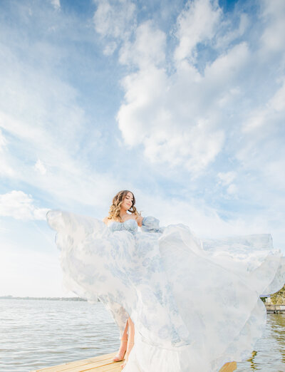 Bride with flowy dress on the water moving around dreamy and sensual