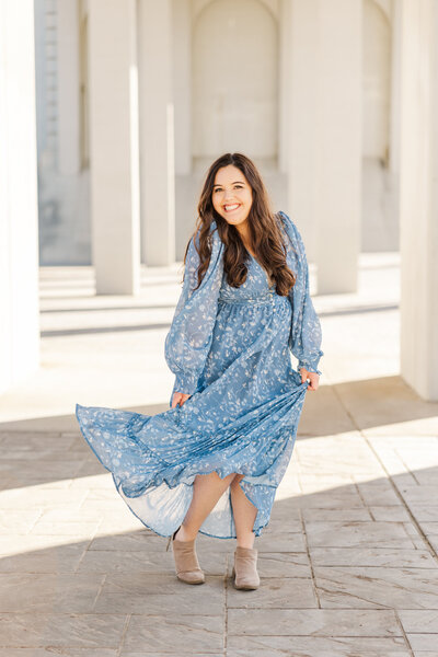 Ivy smiling and twirling in a blue dress