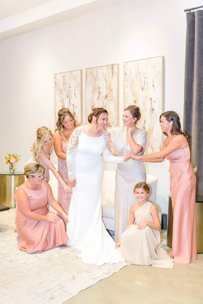 A bride gets ready in the Distillery bridal suite as her bridesmaids fawn on her.