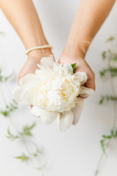 Southern California Wedding  Florist hand's holding a white peony