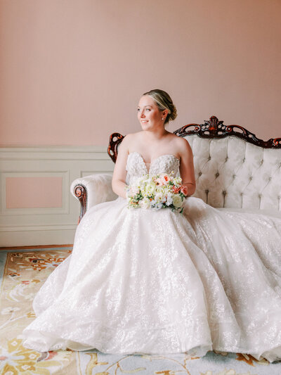 Bride portrait sitting on vintage coach at Aldrich Mansion wedding in Rhode Island