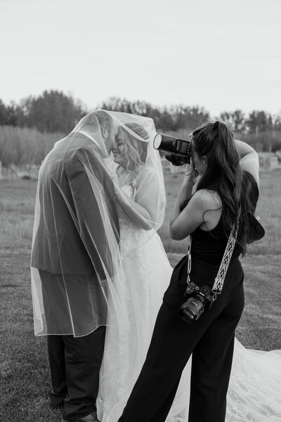 Black and white scene of a photographer capturing a wedding moment