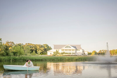 bride and groom in blue row boat at fete of wales