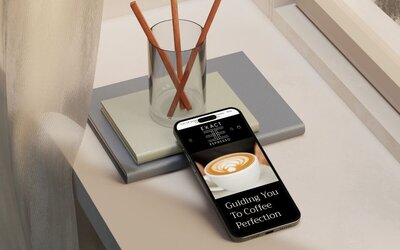 iphone showing exact espresso website, optimised for seo and conversion rate optimisation, with reed diffuser on a desk in background