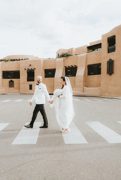Bride and groom walking across the plaza in Santa Fe