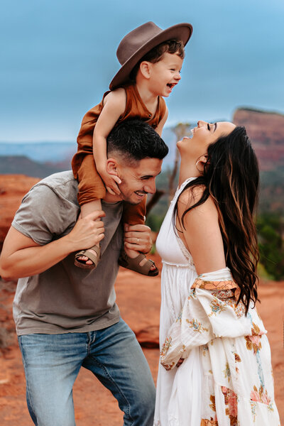 Family laughing with boy on dad's shoulders