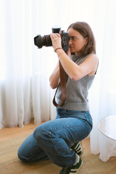 Focused portrait of Bo Eppink, kneeling and carefully composing a shot, demonstrating her dedication and attention to detail in photography.