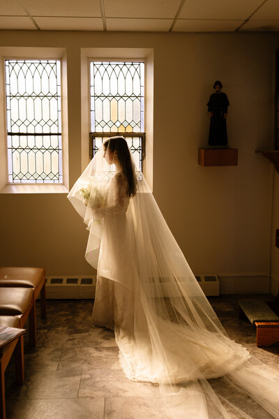 Close up view of delicate wedding dress skirt, wedding bouquet, and heels