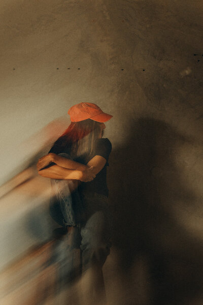 Double exposure effect for wellness business owner sitting on a chair wearing a red cap.