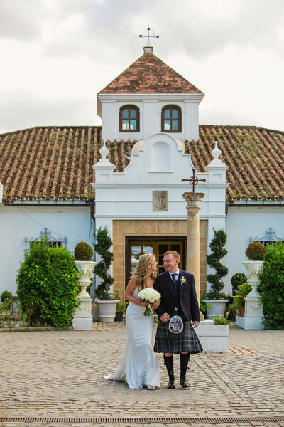 Bride and groom standing outside their typical spanish wedding venue