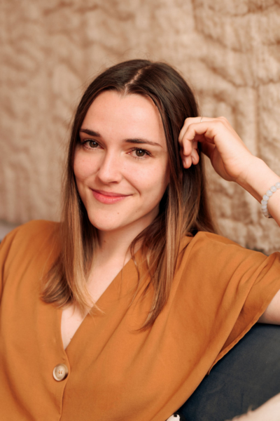 Claire Bostrom, staff somatic psychotherapist, smiling warmly in a Manhattan therapy setting, supporting clients with trauma-informed care.