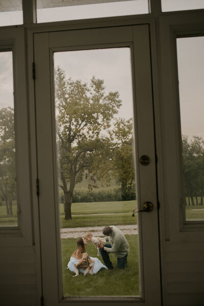 Outdoor family photoshoot in Omaha park during golden hour – capturing candid, heartfelt moments.