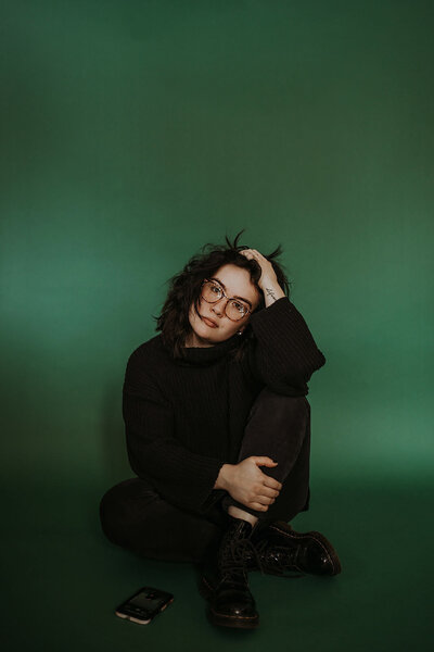 woman sitting in front of green background