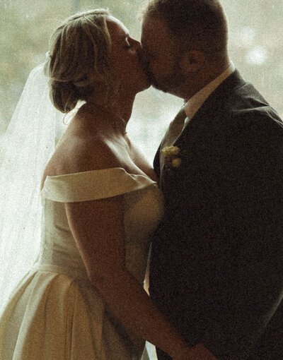 Intimate wedding portrait of a bride and groom sharing a quiet moment together in an outdoor setting