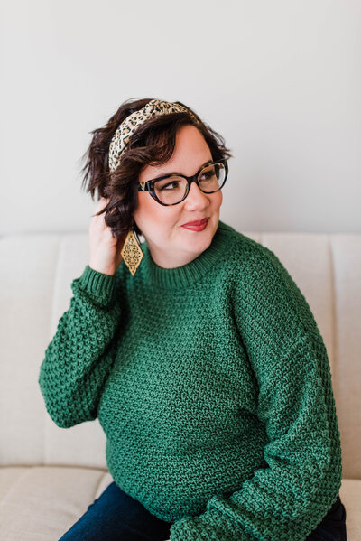 Copywriter Sara Gillis wearing a green sweater and glasses