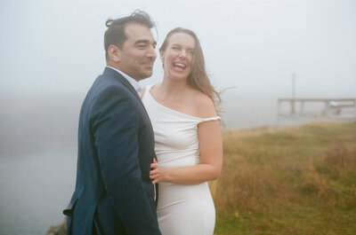 bride laughs and touches groom's chest during elopement ceremony in the mist