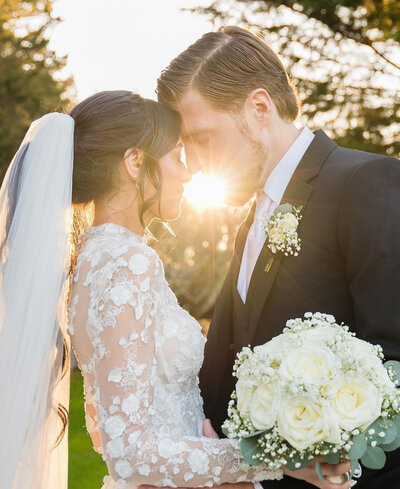 bride and groom kissing at sunset hour at their wedding. Bride is wearing a lace dress altered by Bridal Alterations by Kirstyn, a Long Island seamstress
