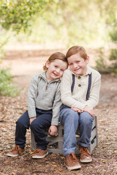 two boys sitting on crate