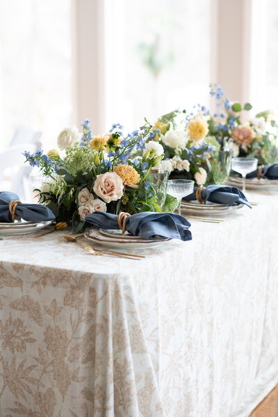 An Austin-based wedding photographer captures a beautifully arranged table setting adorned with vibrant blue and yellow flowers.