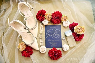 Wedding details including shoes, rings, jewelry & invitation suite