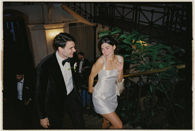 Bride changing into mini dress, dancing with groom at late-night party.