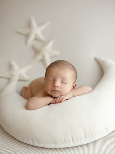 A baby is posed on a moon pillow for a photoshoot in Vancouver