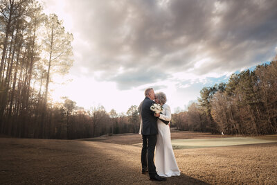 Couple share a moment with the breathtaking Golf course as a background