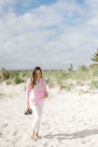 photographer with camera walking on beach