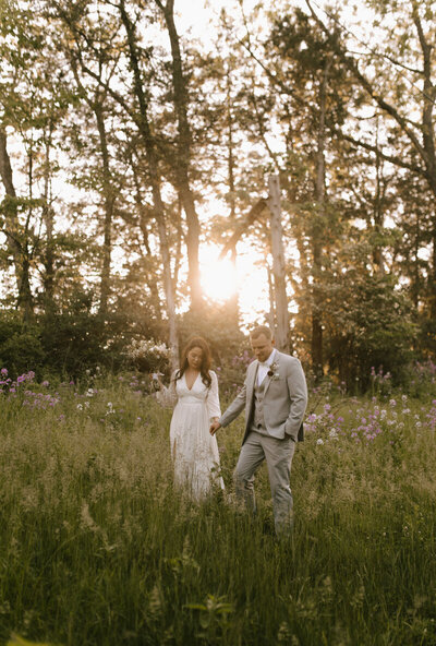 Wedding couple in the field near forest wedding venue in PA.