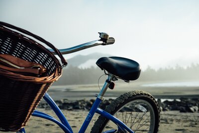 Blue cruiser bicycle with basket parked on the beach